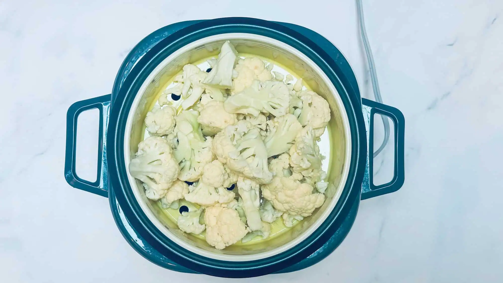 Step 1 for cauliflower tater tots. Steaming cauliflower in steam basket.