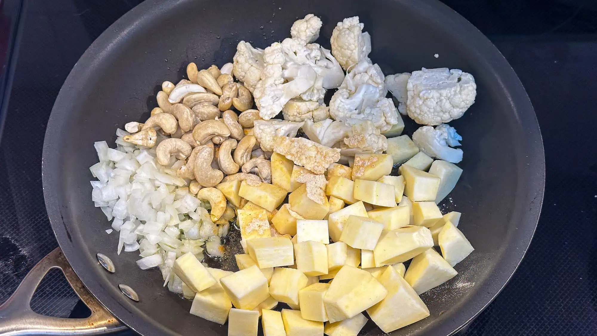 Step 2 for dairy-free mac and cheese, adding ingredients to frying pan with olive oil.