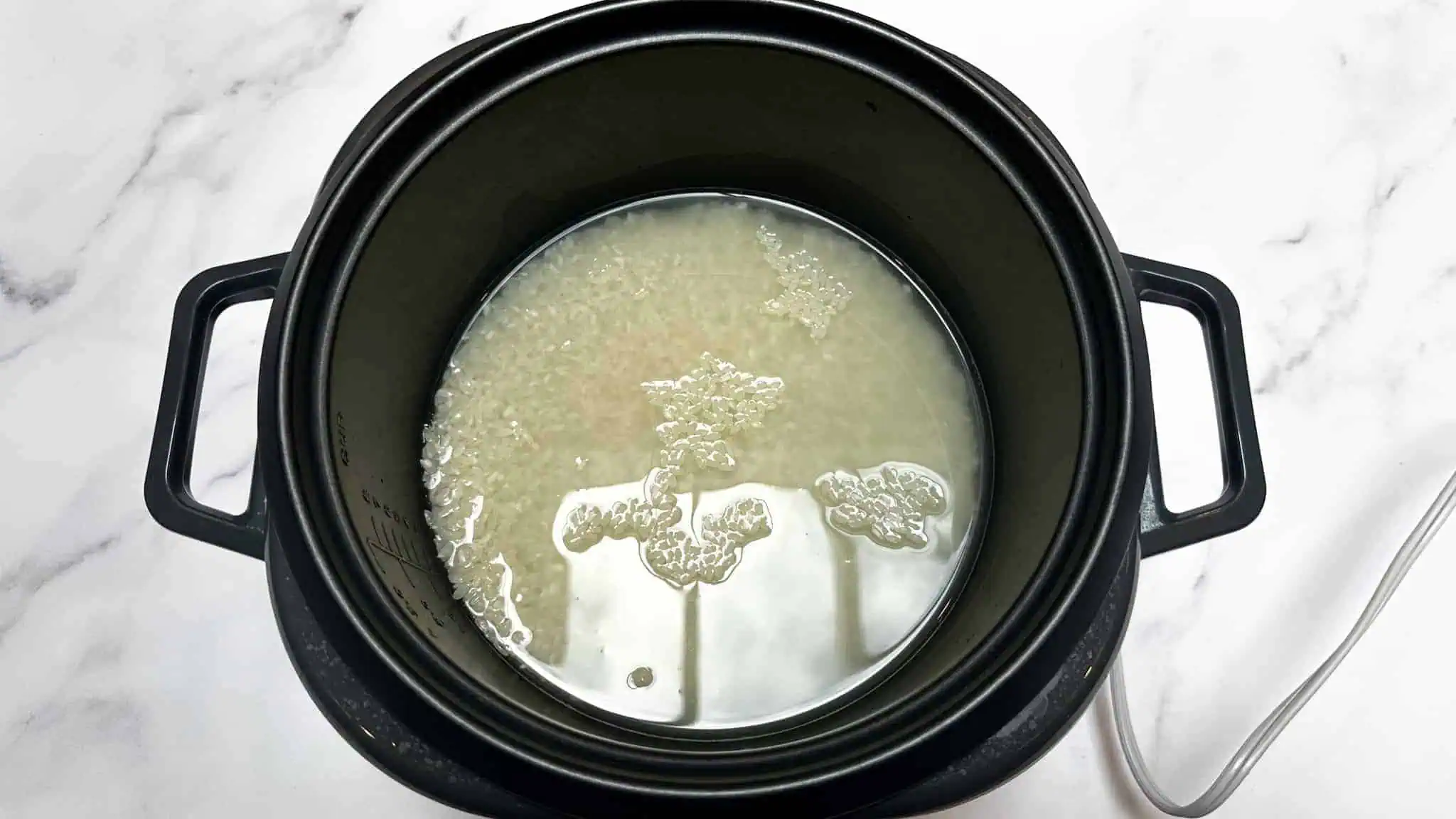 Step 1 of tofu rice bowls, add rice to rice cooker with water.