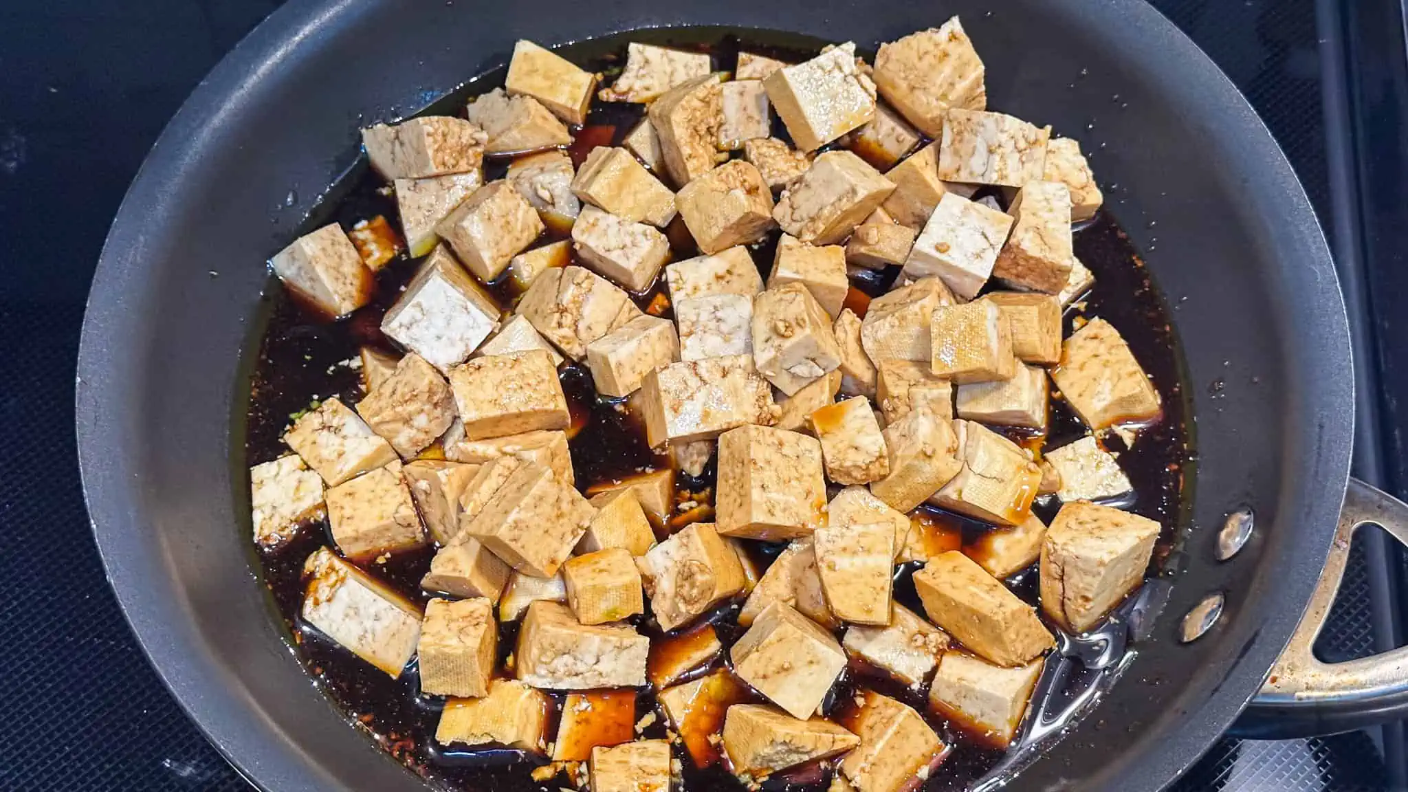 Step 4 of tofu rice bowls - cooking marinaded tofu in skillet.