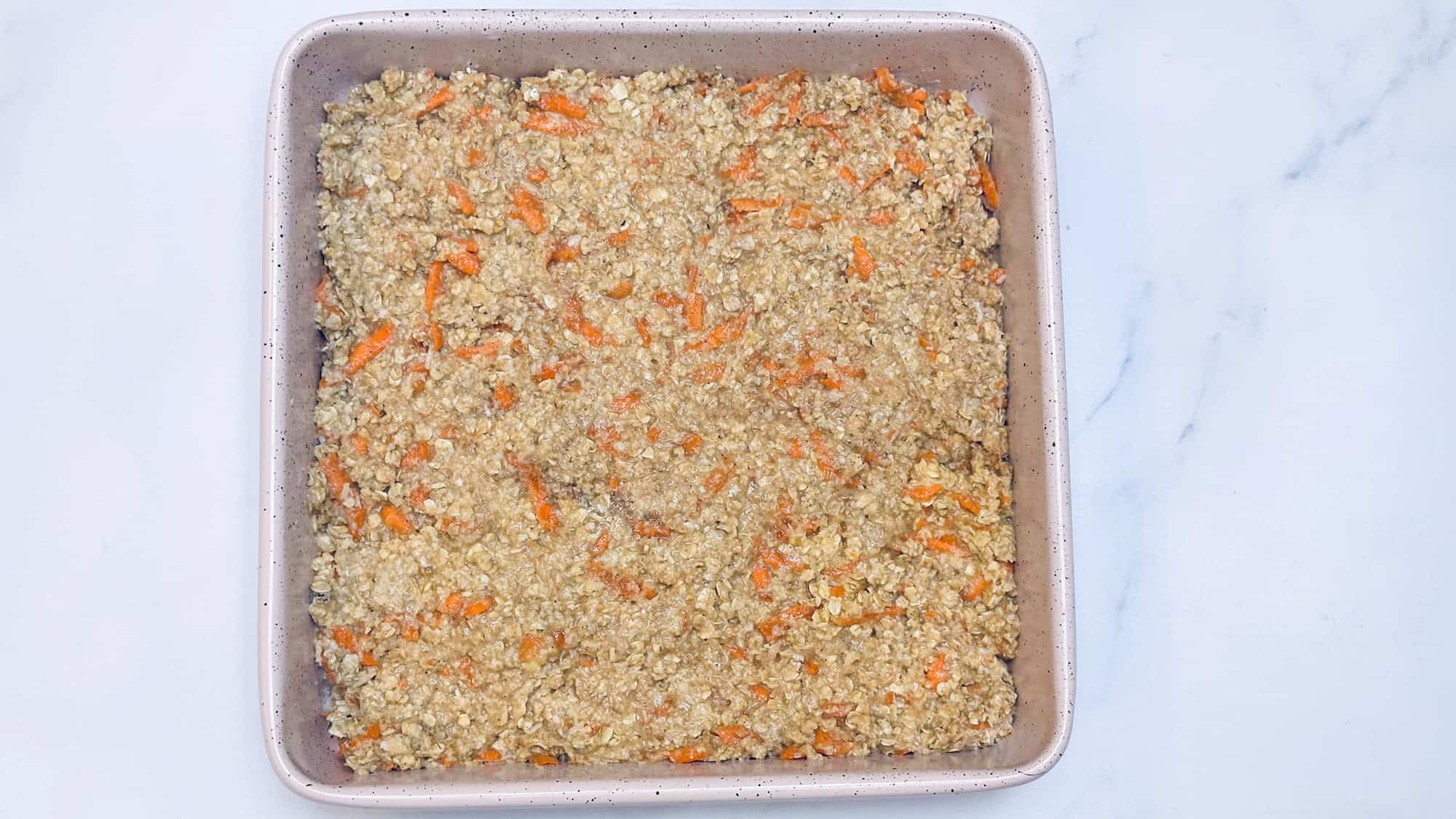 Step 4 for baked carrot cake oatmeal. Dish batter into square baking dish.