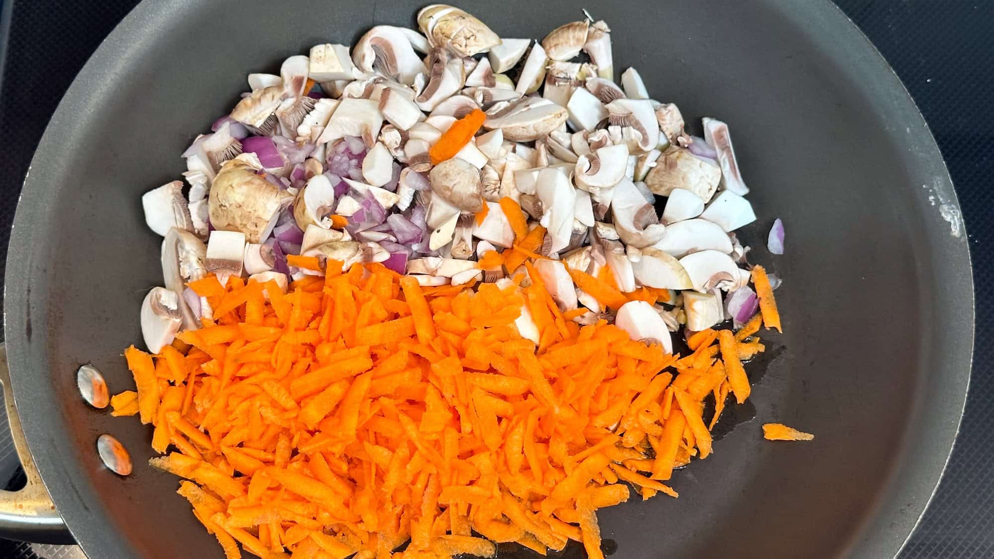 Step 2 of pasta with easy lentil sauce. Add chopped up vegetables to frying pan.