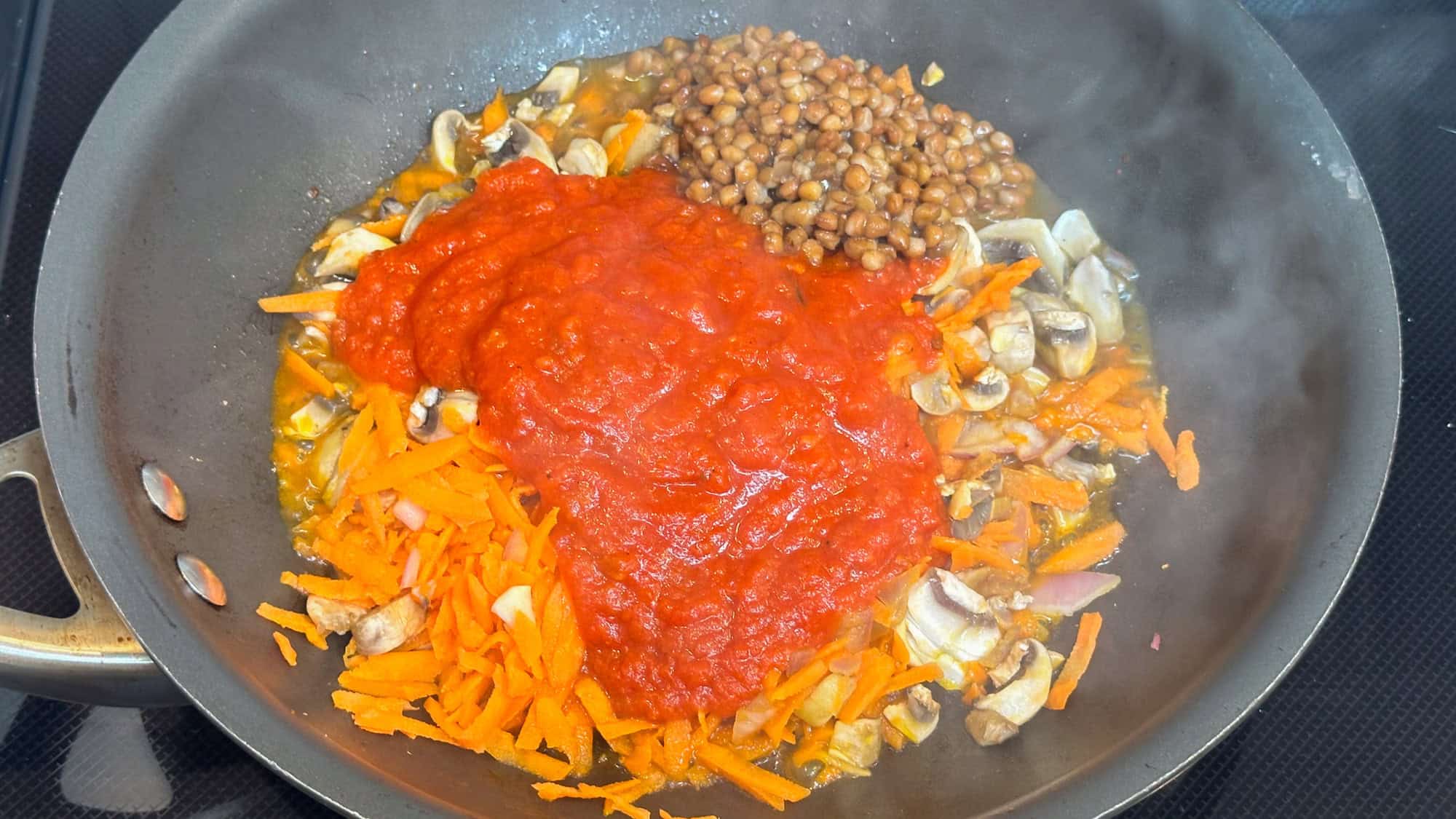 Step 3 of pasta with easy lentil sauce. Add marinara sauce and lentils to pan with vegetables.