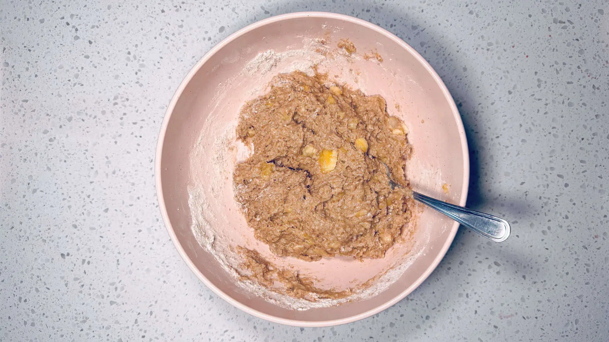 Step 3, wet ingredients are added to dry ingredients and stirred together in a pink bowl.