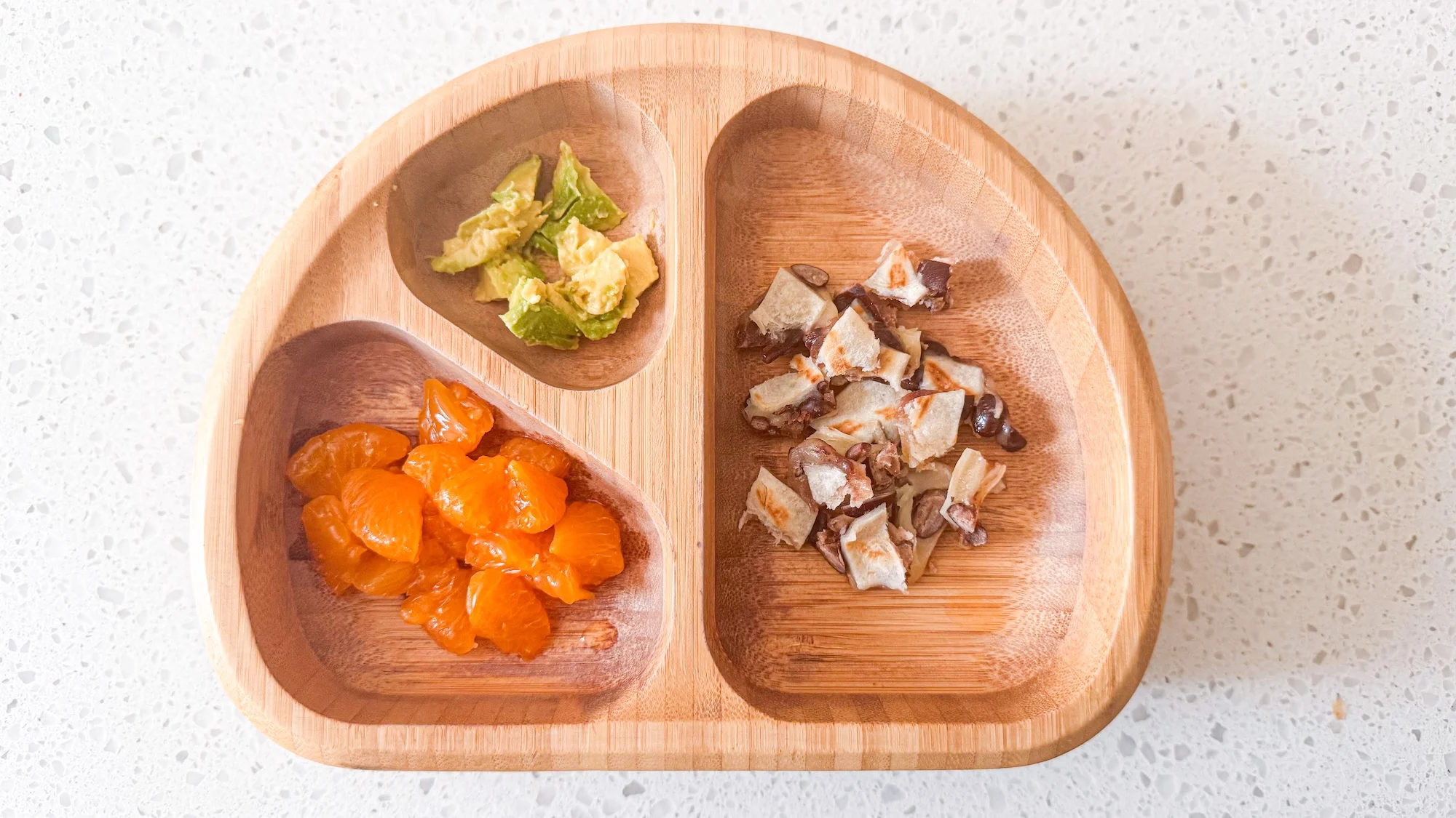Cheese and bean quesadilla with orange and avocado in toddler bowl.