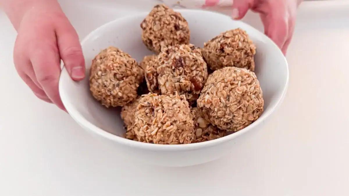 Close up image of toddler holding bowl of energy balls.