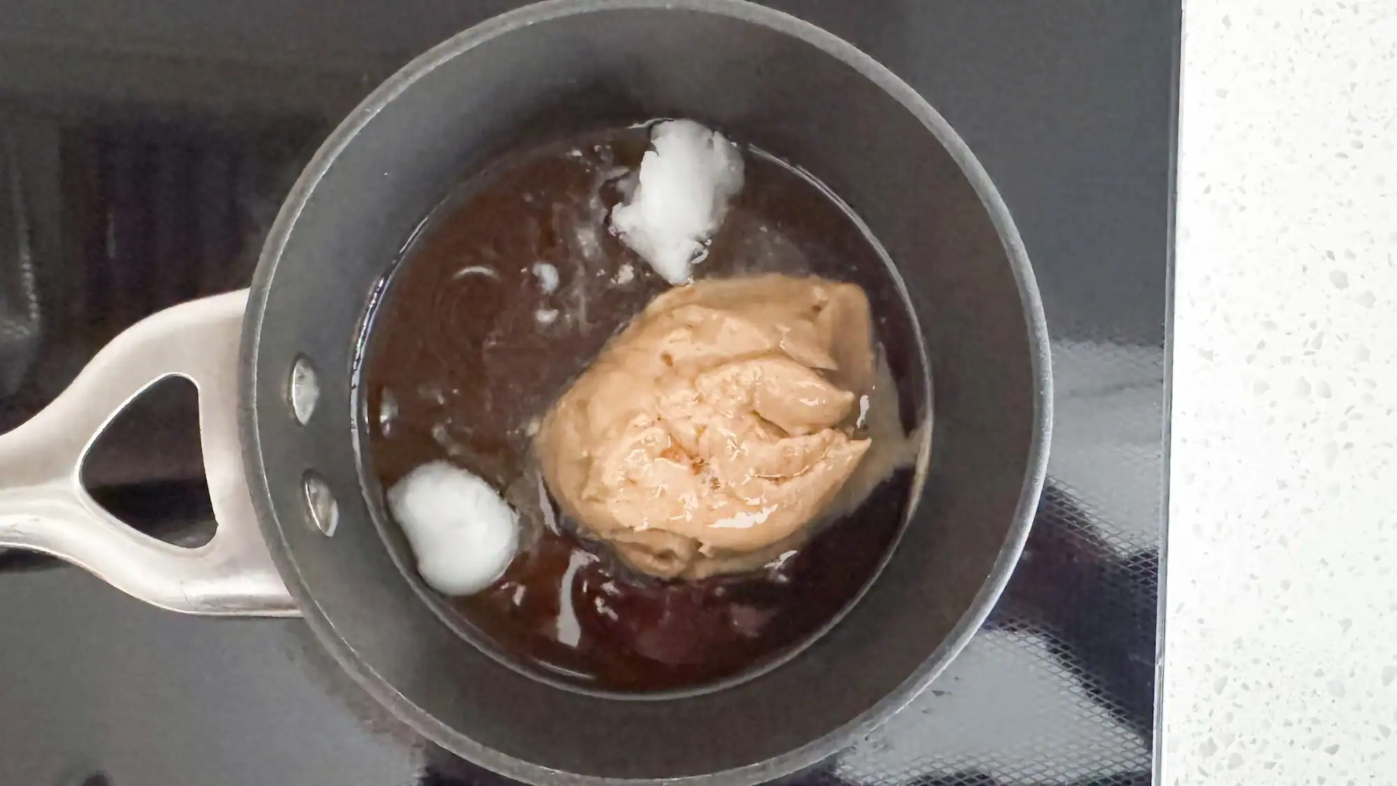 Step 1 for energy balls. Melt coconut oil, tahini and maple syrup in saucepan.