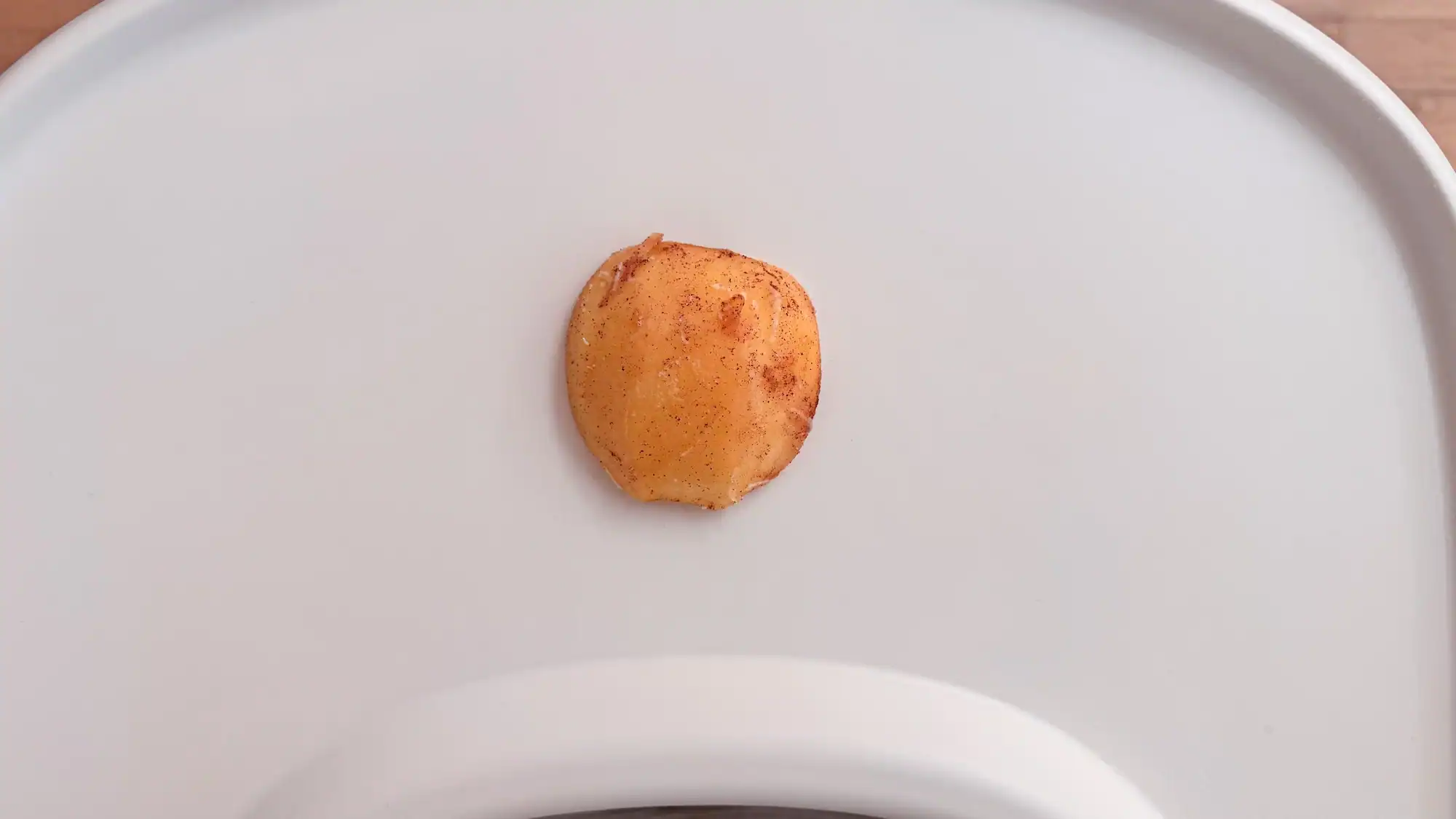 Steamed cinnamon apple half on a baby tray table.