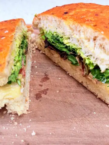 Rotisserie chicken focaccia sandwich with havarti on a cutting board